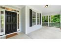 Spacious front porch featuring a ceiling fan and a stylish black front door at 1870 Lennox Dr, Garner, NC 27529