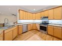Well-lit kitchen featuring stainless steel appliances, granite counters, and wooden cabinets at 1870 Lennox Dr, Garner, NC 27529