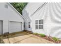 View of the white siding and garage entrance of a home with an adjacent driveway at 2010 Silky Dogwood Trl, Apex, NC 27502