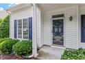 Close-up of the home's front door, showcasing detailed trim and blue shutters at 2010 Silky Dogwood Trl, Apex, NC 27502