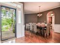 Elegant dining room with hardwood floors, a modern chandelier, and a view to the landscaped front porch at 204 Muirfield Ln, Clayton, NC 27527