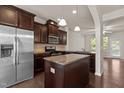 Modern kitchen with stainless steel appliances, granite countertops, and dark wood cabinets at 220 Mount Evans Dr, Durham, NC 27705
