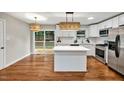 Bright, modern kitchen with white cabinets, an island, pendant lights, and stainless steel appliances at 2200 Wyman Pl, Durham, NC 27707