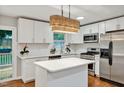 Modern eat-in kitchen featuring white cabinets, stainless steel appliances, and a bright island at 2200 Wyman Pl, Durham, NC 27707