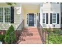 Inviting front porch with brick steps, black railing, and a view of the well-maintained lawn at 231 Heather Bluffs Dr, Garner, NC 27529