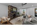 Comfortable living room with a stone fireplace, ceiling fan and lots of natural light at 2500 Plowridge Rd, Fuquay Varina, NC 27526