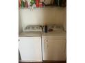 Washer and dryer units in dedicated laundry area with shelving at 3000 Centennial Woods Dr # 302, Raleigh, NC 27603