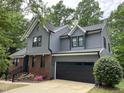 Striking two-story home features gray siding, black trim, brick accents, and a convenient two-car garage at 306 Roebling Ln, Cary, NC 27513
