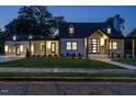 Beautiful two-story home with modern black-and-white design elements, illuminated for a warm evening glow at 316 Barbour St, Clayton, NC 27520