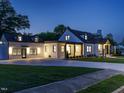 Charming two-story home, illuminated at dusk, showcasing its extended driveway and manicured lawn at 316 Barbour St, Clayton, NC 27520