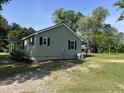 Side view of a single-story house with a black metal roof and green vinyl siding at 317 Brewer Rd, Louisburg, NC 27549