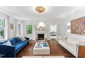 Elegant living room with fireplace, hardwood floors, and white sofas, bathed in natural light at 3210 Merriman Ave, Raleigh, NC 27607