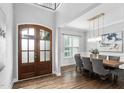 Elegant dining room with a modern light fixture, large windows, and hardwood floors at 329 Royal Delta Dr, Cary, NC 27519