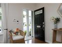 Bright entryway featuring a black door with glass accents, and a charming accent chair at 365 Red Elm Dr, Durham, NC 27713