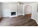 Bright living room with a white fireplace, hardwood floors, ceiling fan, and arched doorway at 4509 Cobble Creek Ln, Raleigh, NC 27616