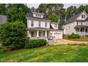 Landscaped front yard view of home with a welcoming front porch and attached garage at 507 Vatersay Dr, Apex, NC 27502