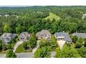 Aerial view of a luxurious home nestled among lush greenery and scenic views with neighboring houses at 671 Bear Tree Crk, Chapel Hill, NC 27517