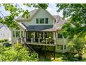 A home's backyard featuring a spacious deck, stairs, and lush greenery at 671 Bear Tree Crk, Chapel Hill, NC 27517