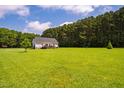 Spacious backyard with a large, green lawn and a view of the surrounding trees at 6916 Morrow Mill Road, Chapel Hill, NC 27516