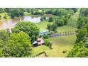 Aerial view of estate featuring a private pond, mature trees, and ample acreage at 771 Cedar Grove Church Rd, Roxboro, NC 27574