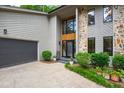 Close up of the home's front entrance, showcasing stone and wood accents plus a gray garage door at 7816 Harbor Dr, Raleigh, NC 27615
