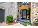 Close up of home's front entrance and door with stone accents and lush landscaping at 7816 Harbor Dr, Raleigh, NC 27615