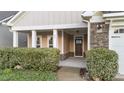 Inviting covered front porch with stone accents and a well-maintained landscape at 80 Bramble Ln, Clayton, NC 27527