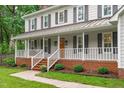 Inviting front porch with white railings, brick accents, and a warm, welcoming entrance at 8505 Stonegate Dr, Raleigh, NC 27615