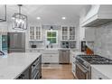 Modern kitchen featuring white cabinets, stainless steel appliances, and stylish marble backsplash at 8505 Stonegate Dr, Raleigh, NC 27615