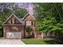 Traditional two-story brick home with an attached two-car garage and mature landscaping at 8816 Valley Springs Pl, Raleigh, NC 27615
