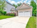 Two car garage featuring a large driveway and manicured lawn at 921 Shefford Town Dr, Rolesville, NC 27571
