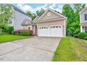 Home exterior showcasing its well-kept lawn, shrubbery, and concrete driveway at 921 Shefford Town Dr, Rolesville, NC 27571