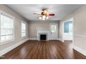 Bright living room featuring a decorative fireplace, wood floors, and natural light from large windows at 1001 N Orange Ave, Dunn, NC 28334