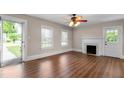 Inviting living room boasts wood floors, a decorative fireplace, and natural light from large windows and glass door at 1001 N Orange Ave, Dunn, NC 28334