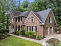 A brick and siding home has an attached two-car garage and well-maintained landscaping at 1004 Staffield Lane Ln, Chapel Hill, NC 27516