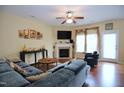 Comfortable living room features a ceiling fan, fireplace, hardwood floors and large windows for natural light at 101 Claystone Dr, Gibsonville, NC 27249