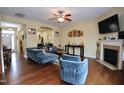 Spacious living room boasts hardwood floors, a ceiling fan, and a cozy fireplace at 101 Claystone Dr, Gibsonville, NC 27249