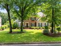 Beautiful two-story home with brick and siding, surrounded by mature trees and a well-maintained lawn at 105 Spring Bud Dr, Cary, NC 27513