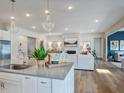Bright open kitchen with a large island, stainless steel appliances, and hardwood floors at 1107 Masters Place Way # 155, Durham, NC 27703
