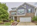 Charming two-story brick and siding home featuring a two-car garage, a lush green lawn, and mature trees at 112 Filigree Way, Durham, NC 27713