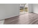 Living room showcasing wood-look flooring and natural light from the sliding glass door at 1201 Solace Way, Rolesville, NC 27571