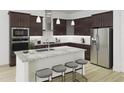 Well-equipped kitchen with stainless steel appliances, center island with seating, and dark wood cabinetry at 1205 Masters Place Way # 183, Durham, NC 27703
