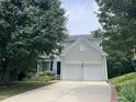 Charming two-story home with a two-car garage, neat landscaping, and mature trees at 122 Button Rd, Morrisville, NC 27560
