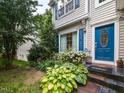 Close-up of a house with a blue front door and manicured landscaping around the entrance at 122 Button Rd, Morrisville, NC 27560