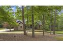 Brick home nestled among trees with an inviting driveway, offering a sense of privacy and natural beauty at 13121 Melvin Arnold Rd, Raleigh, NC 27613
