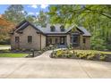 Inviting brick home with mature trees and landscaped front yard, showcasing a well-maintained exterior at 13121 Melvin Arnold Rd, Raleigh, NC 27613