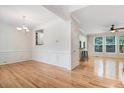 Open-concept living room with hardwood floors, crown molding, and a ceiling fan at 1480 Big Leaf Loop, Apex, NC 27502
