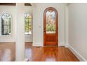 Bright foyer featuring hardwood floors, decorative front door, and arched windows allowing natural light at 15 Treviso Pl, Durham, NC 27707