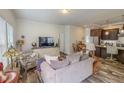 Cozy living room featuring wood floors, a comfortable sofa, and a large television at 153 Bywood Dr, Roxboro, NC 27573