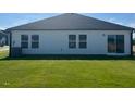 The back exterior of this home features well-maintained lawn, sliding glass door and several windows for ample natural light at 16 Vale Spring Ln, Lillington, NC 27546